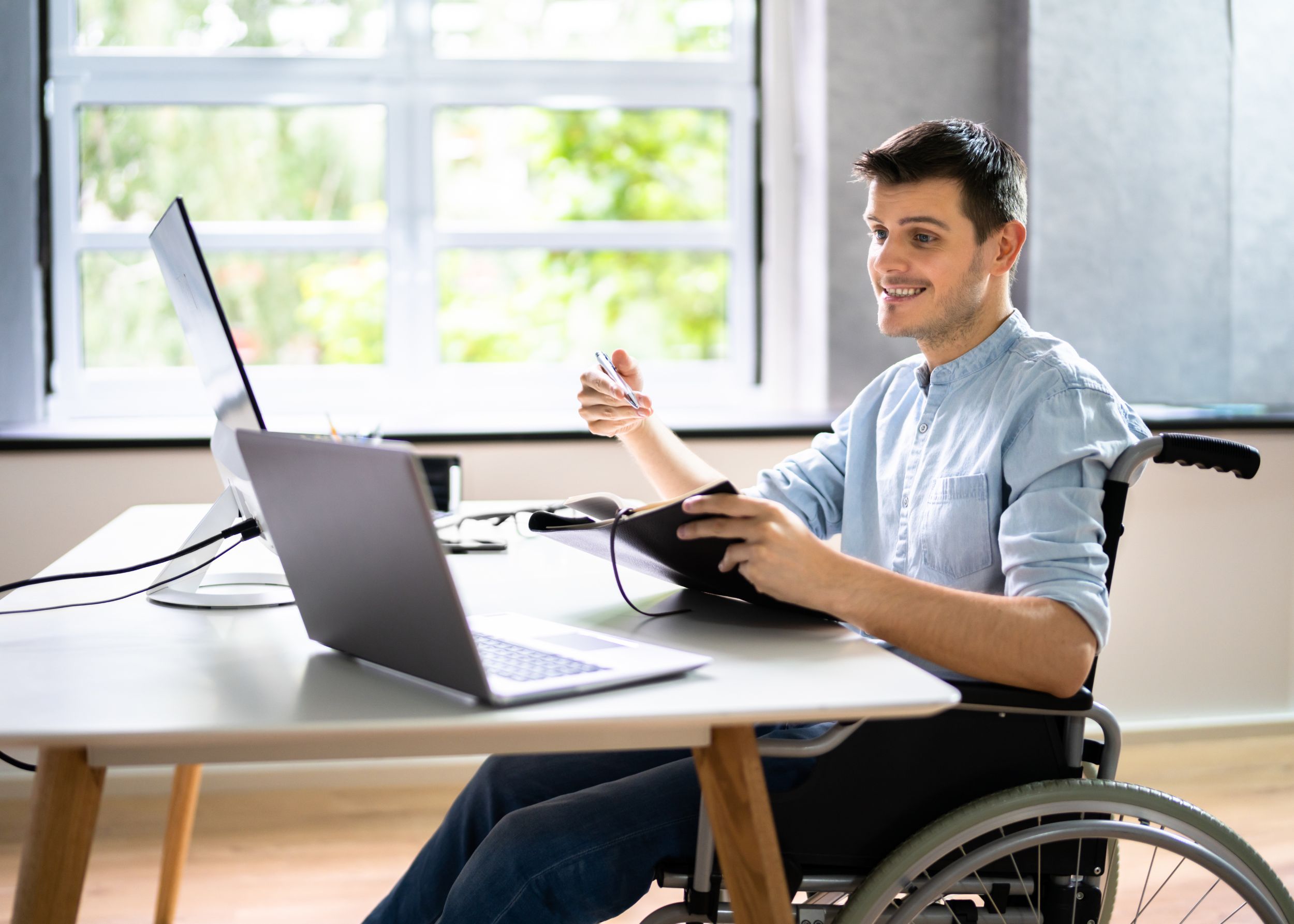 Young man in wheelchair receiving online coaching